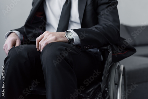 partial view of disable man in black suit and watch sitting in wheelchair © LIGHTFIELD STUDIOS