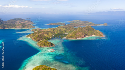 aerial view tropical islands with blue lagoon, coral reef and sandy beach. Palawan, Philippines. Islands of the Malayan archipelago with turquoise lagoons.