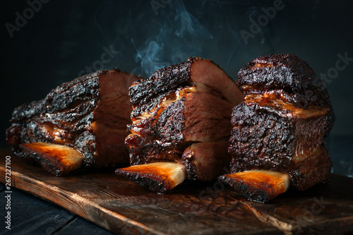 Fotografia, Obraz A large steaming fragrant piece of baked beef brisket on the ribs with a dark crust