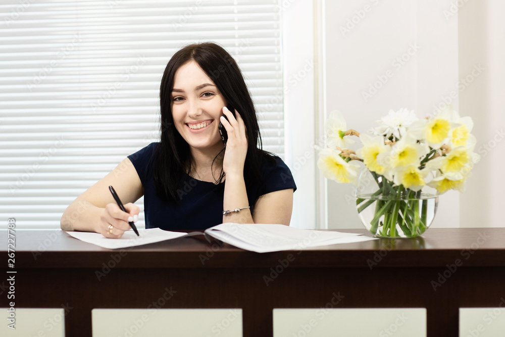 Beautiful girl at the reception desk answering the call in dental office Beautiful girl at the reception desk answering the call in dental office