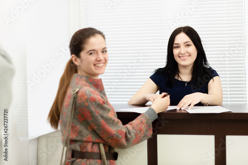 Young woman administrator in a dental clinic in the workplace. Admission of the client