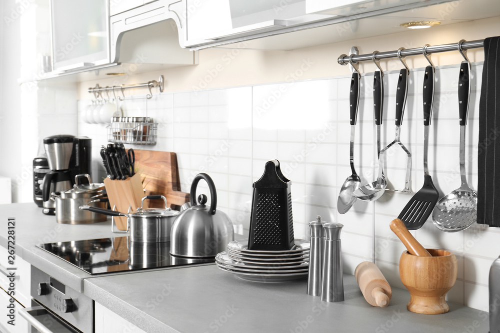 Different appliances, clean dishes and utensils on kitchen counter - obrazy, fototapety, plakaty 