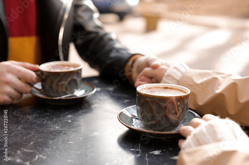 Couple enjoying tasty aromatic coffee at table  closeup view