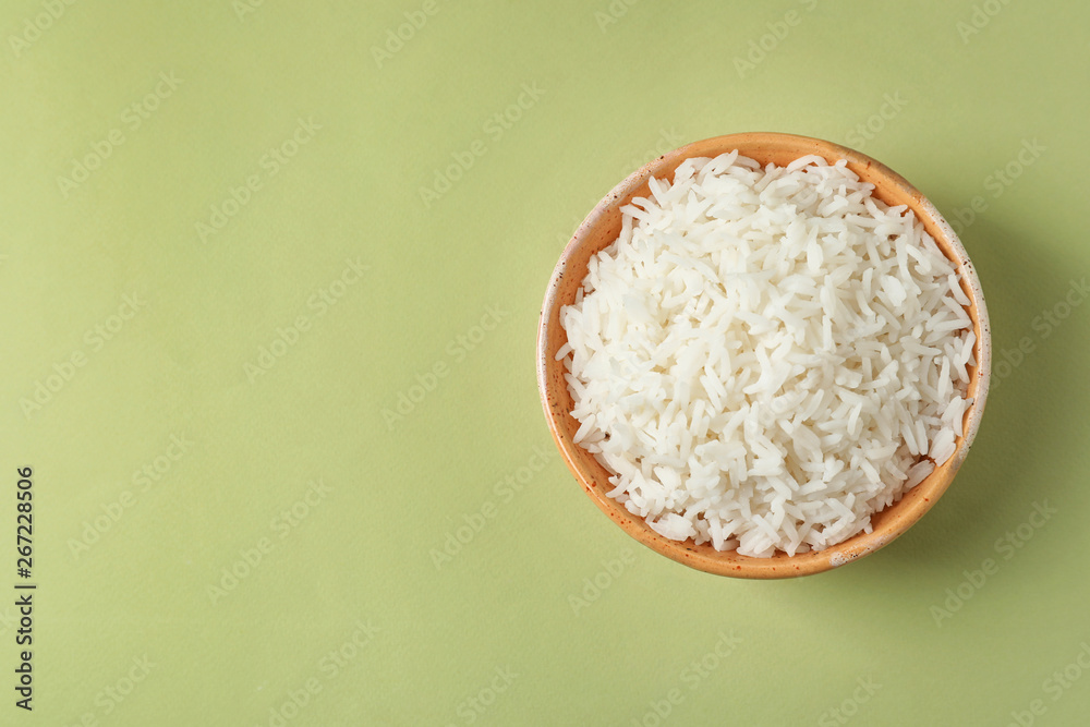 Bowl of tasty cooked rice on color background, top view. Space for text Bowl of tasty cooked rice on color background, top view. Space for text