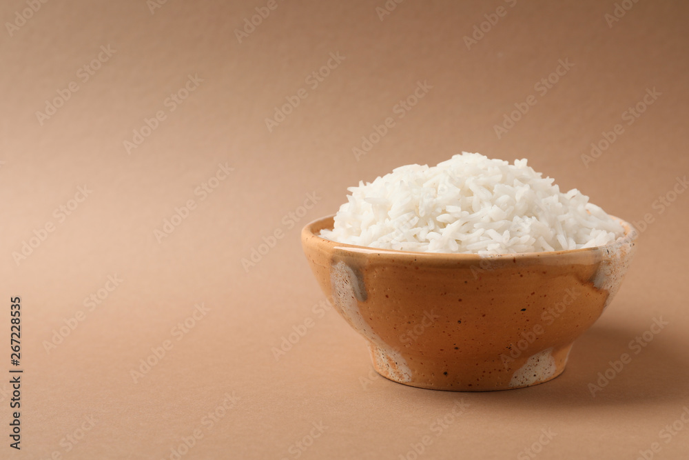 Bowl of tasty cooked rice on color background. Space for text Bowl of tasty cooked rice on color background. Space for text