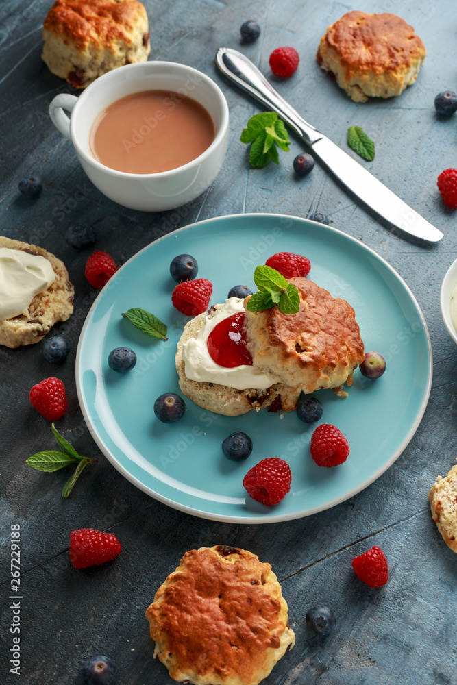 Classic scones with clotted cream, strawberries jam, english Tea and other fruit