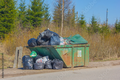 Garbage bin with trash bags. A whole container of garbage near the road.
