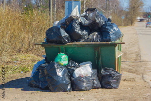 Garbage bin with trash bags. A whole container of garbage near the road.