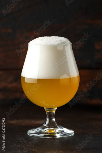 Glass of chilled, cold unfiltered beer on wooden background