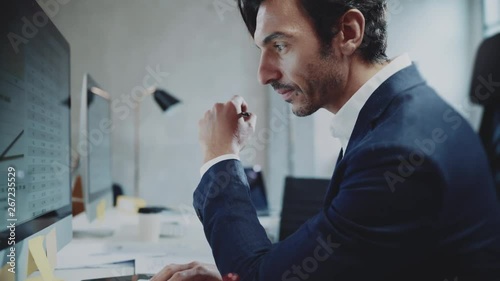 Businessman working at sunny office on desktop computer while sitting at the table.Blurred background.