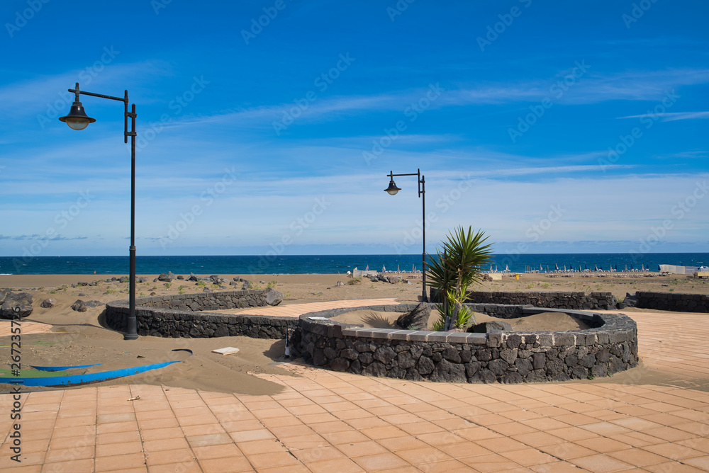 Promenade of Playa grande with blue sky and sea in the background in Puerto del Carmen, Lanztarote, Spain