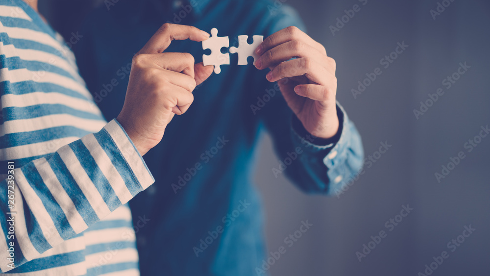 jigsaw puzzle holding by two people hands, together to success concept