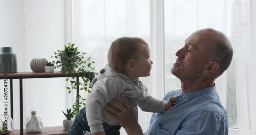 Old man having fun with baby granddaughter at home Old man having fun with baby granddaughter at home