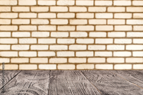 Wooden surface on the background of deorated brick wall