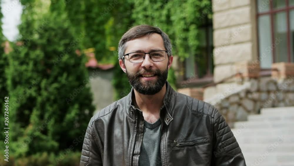 Portrait of attractive bearded man looking into the camera and smiling in slow motion Portrait of attractive bearded man looking into the camera and smiling in slow motion