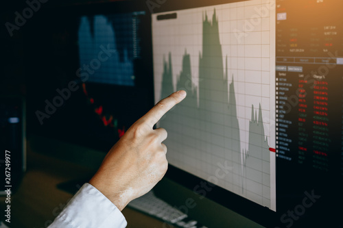 Close up of hand businessman pointing graph and analysis stock market on computer in office.