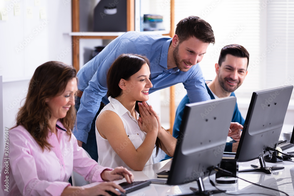 Businessman Standing And Speaking To His Coworkers Businessman Standing And Speaking To His Coworkers