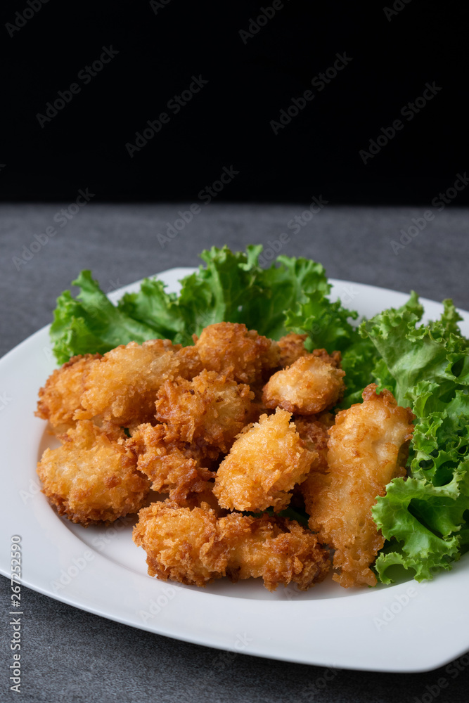 Fried chicken and lettuce in white dish on table. Fried chicken and lettuce in white dish on table.