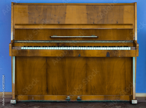 Photography Old wooden piano. Brown piano stands against the wall