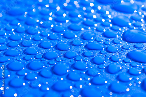 Transparent still water drops on light blue background. Blue water drops. Drops of rain on glass. Blue abstract water drop background. Water surface