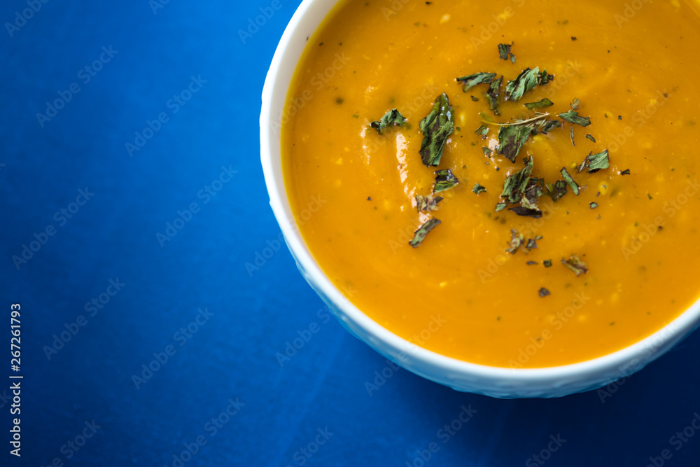 Pumpkin cream soup. Fresh soup with herbs on a background, Autumn concept. Tasty healthy food.