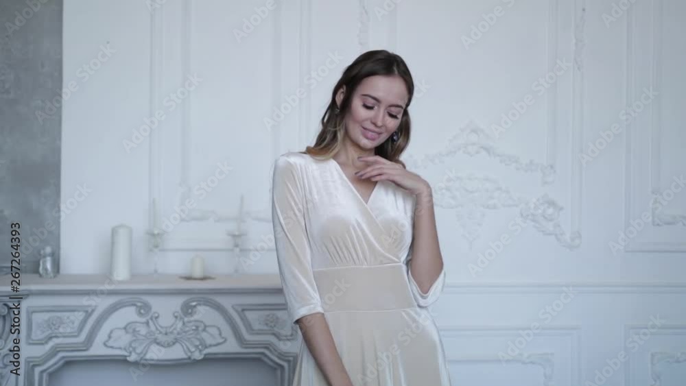 Gorgeous girl on the background of the fireplace, posing in an elegant beautiful dress. Slow motion Gorgeous girl on the background of the fireplace, posing in an elegant beautiful dress. Slow motion