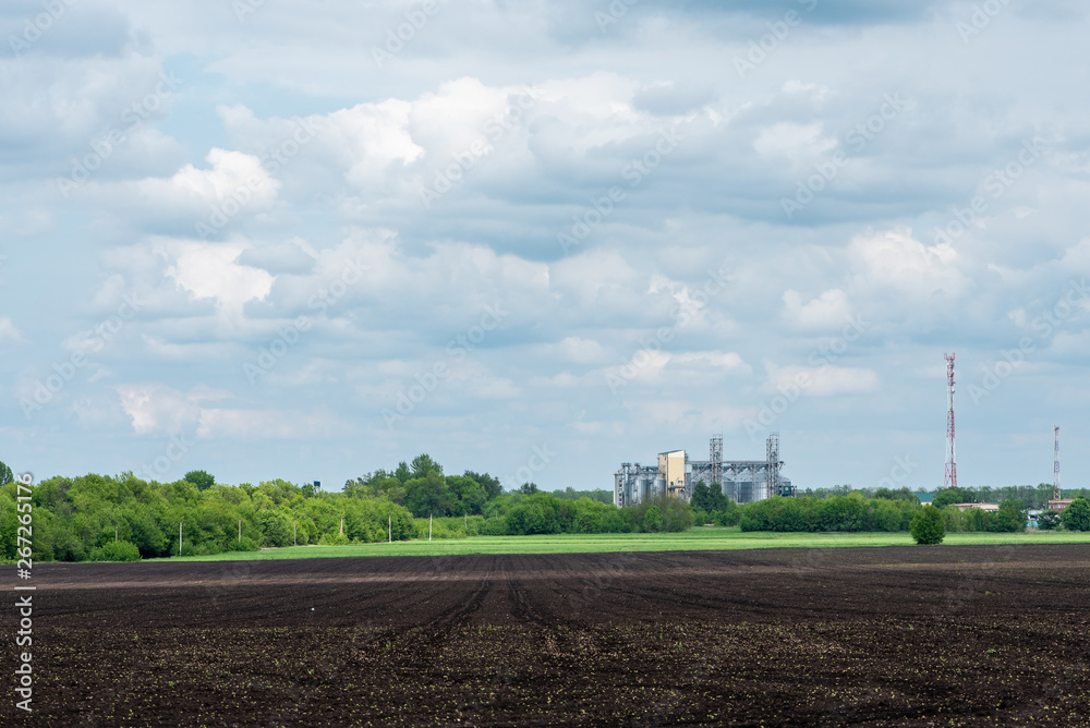 Plowed agricultural field and granary. Rural landscape. Plowed agricultural field and granary. Rural landscape.