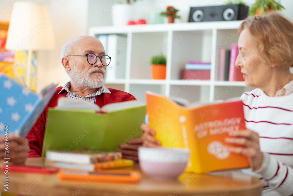 Pleasant senior people enjoying reading different books Pleasant senior people enjoying reading different books