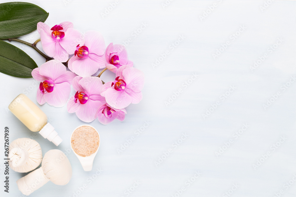 Sea salt, aromatherapy oil in bottles and orchid on vintage wooden background.