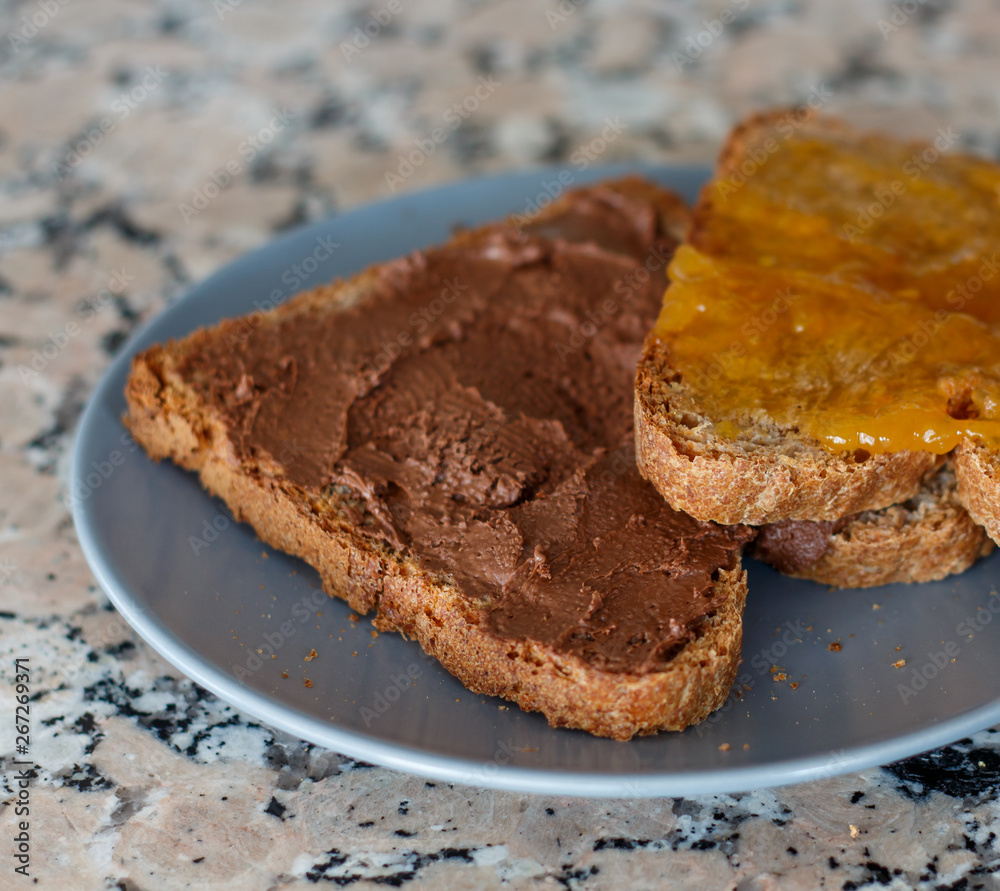 Slice toast with cocoa cream and peach jam on blue plate Slice toast with cocoa cream and peach jam on blue plate
