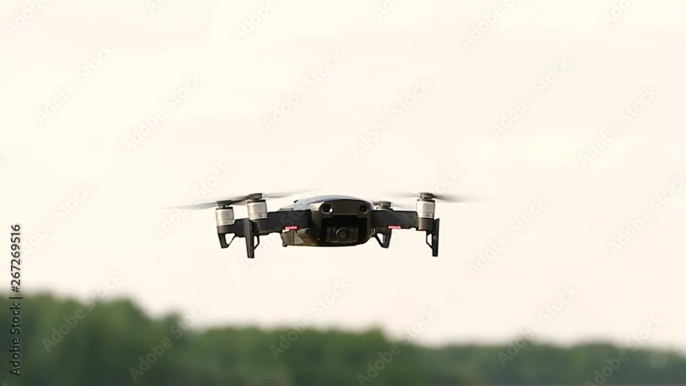 Quadcopter drone close-up flying over the field, in the agricultural area on a summer day Quadcopter drone close-up flying over the field, in the agricultural area on a summer day