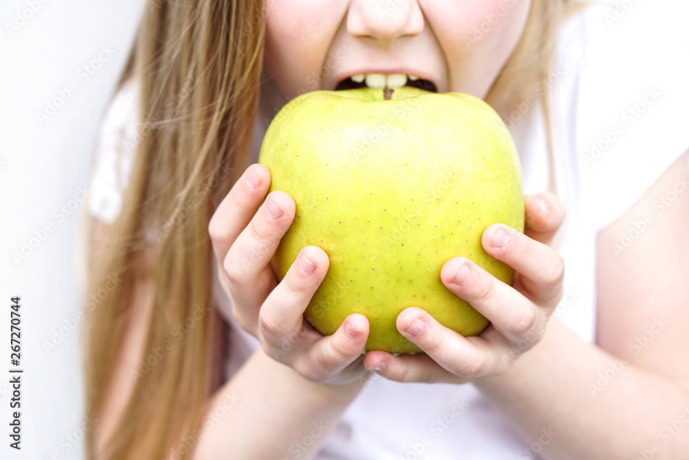 Big yellow green apple in children s hands . Girl biting the apple Big yellow green apple in children s hands . Girl biting the apple