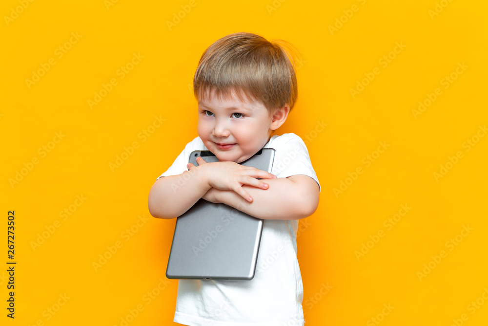 happy cute boy hugging his lovely tablet computer pc, Z generation, children who was born with technology happy cute boy hugging his lovely tablet computer pc, Z generation, children who was born with technology