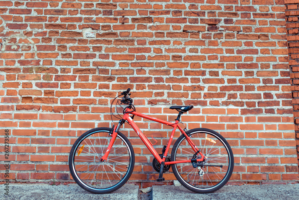 Red city bike in the summer in city on a brick wall background. The concept of parking, bike, rest in the city, cycling. Free space for text. Red city bike in the summer in city on a brick wall background. The concept of parking, bike, rest in the city, cycling. Free space for text.