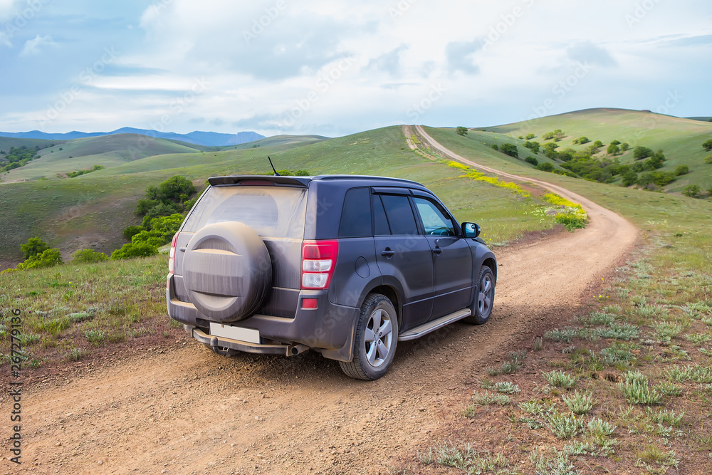 off-road car moves along a dirt mountain road