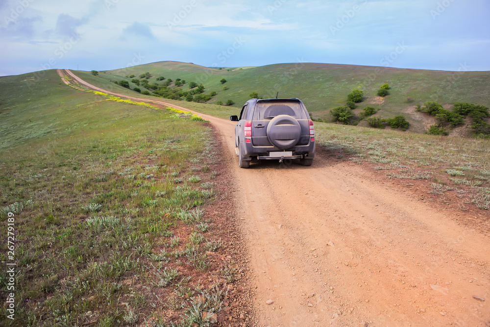 off-road car moves along a dirt mountain road off-road car moves along a dirt mountain road