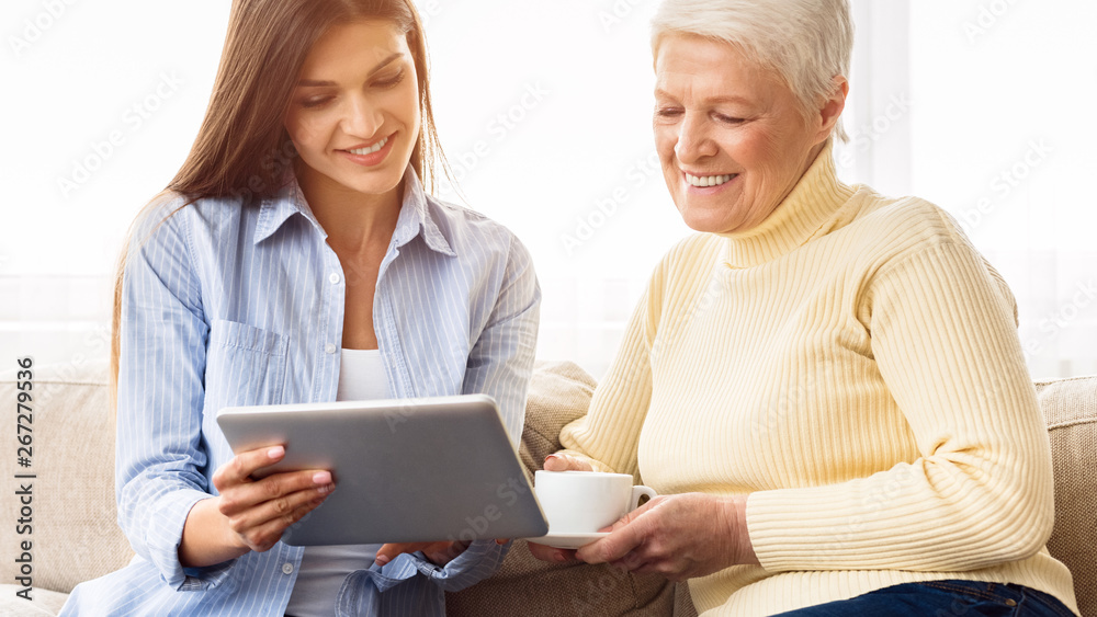 Daughter teaching her senior mother using tablet Daughter teaching her senior mother using tablet
