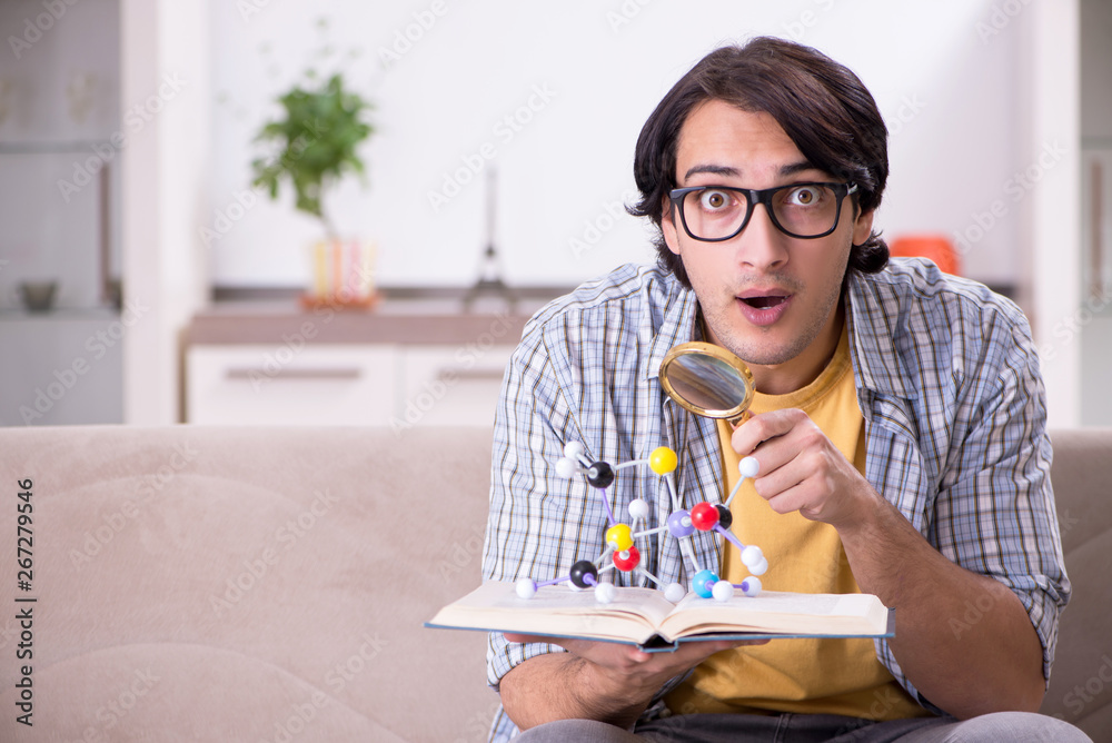 Young student physicist preparing for exam at home Young student physicist preparing for exam at home