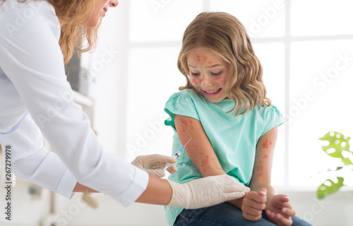 Measles Vaccination. Doctor Injecting Vaccine To Child Girl