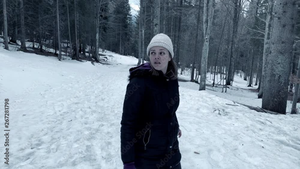 Woman in forest with snow running away scared horror