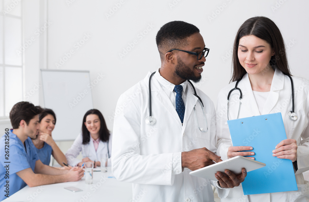 Discussing Diagnosis. Diverse Doctors Using Digital Tablet Discussing Diagnosis. Diverse Doctors Using Digital Tablet