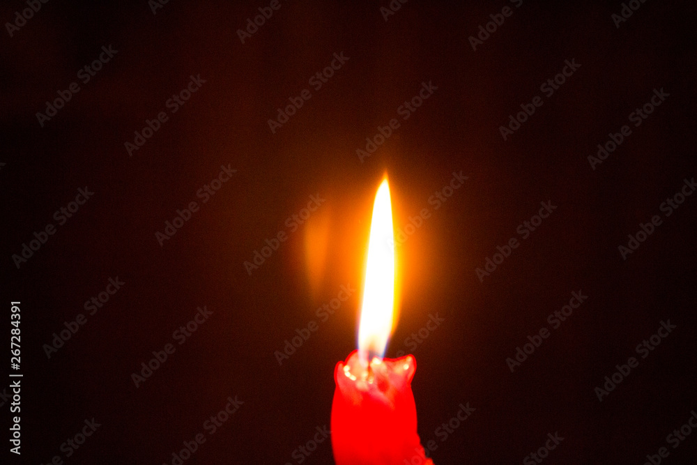 Red burning candle in the dark - mystery and romance, time of love and passion Red burning candle in the dark - mystery and romance, time of love and passion