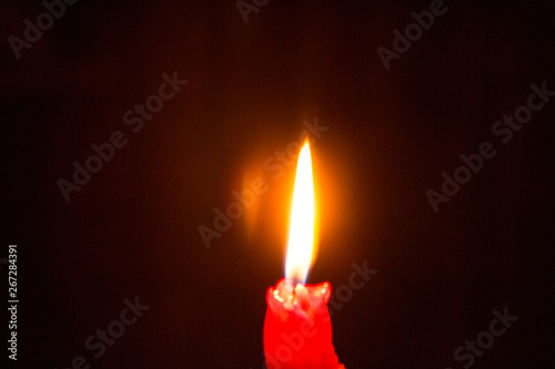 Red burning candle in the dark - mystery and romance, time of love and passion