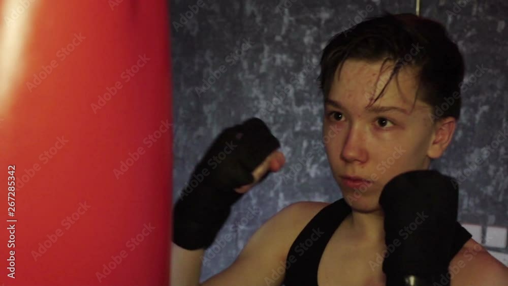 A teenager in a black t-shirt in Boxing training. Slow motion A teenager in a black t-shirt in Boxing training. Slow motion