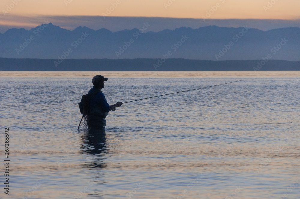 A fisherman tries to catch a fish in the Puget Sound water