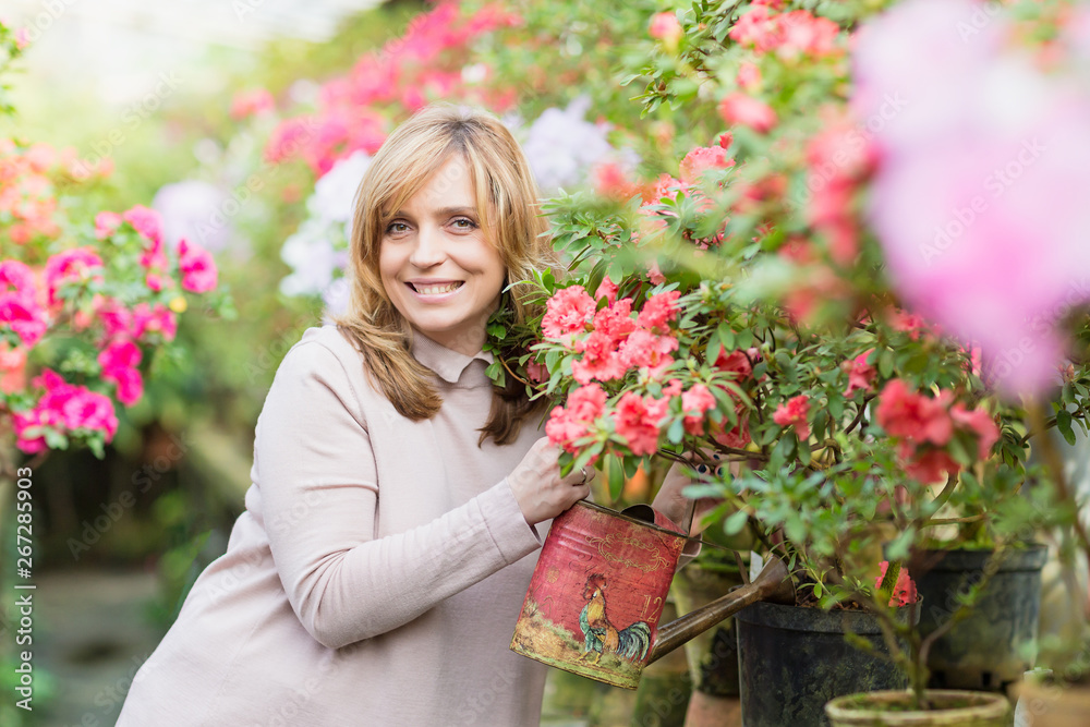 Beautiful woman watering plants and gardening in greenhouse. Beautiful woman watering plants and gardening in greenhouse.