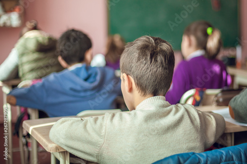 school children are participating actively in class, working at laptop