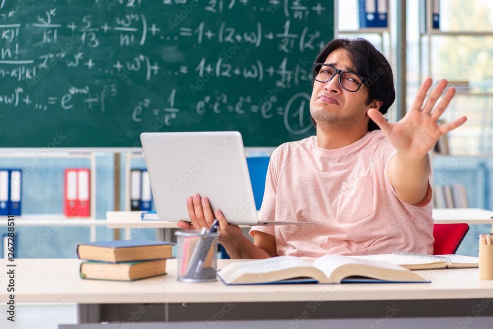 Young male student in the classroom Young male student in the classroom