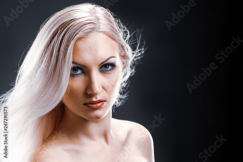 Fashion model with shiny blonde hairstyle on black background