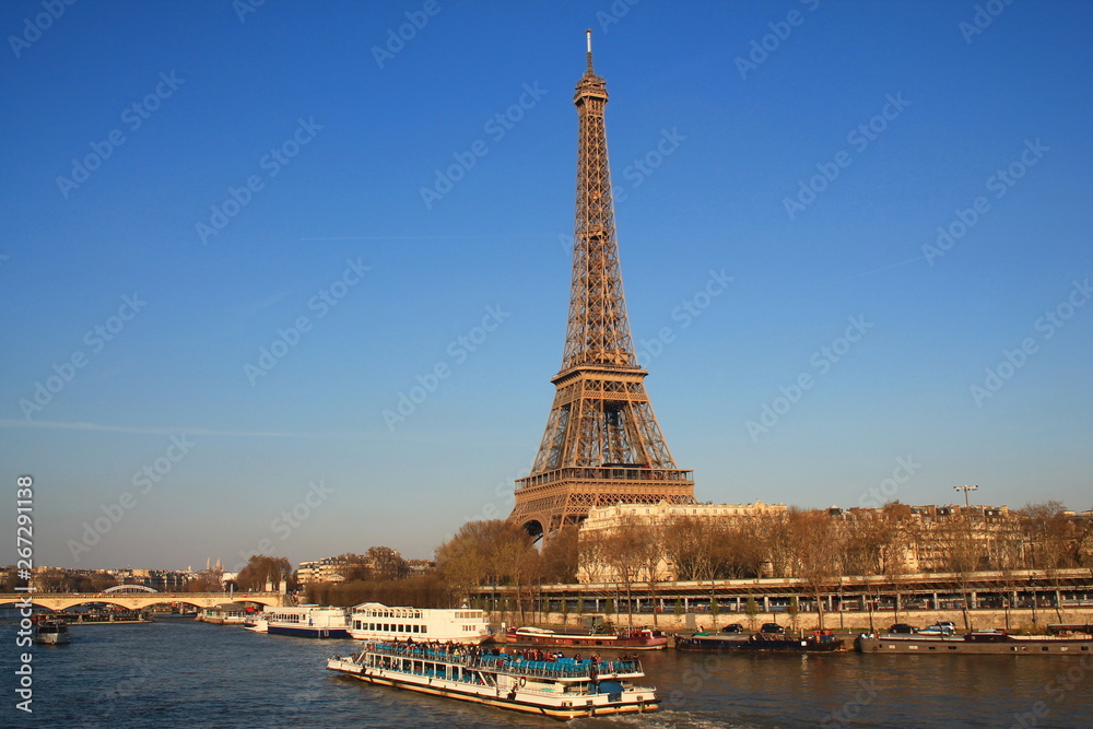 The Eiffel tower in evening and river boat on the seine river in Paris, Paris capital and the most populous city of France